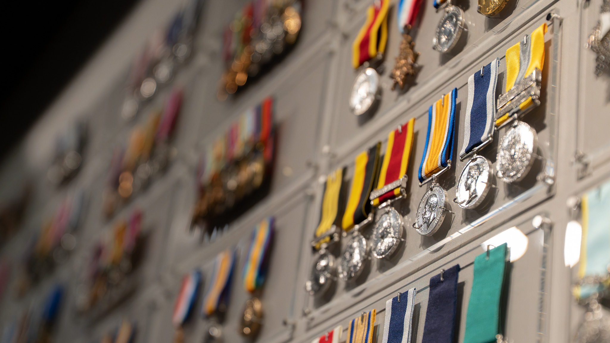 Wall display of medals and ribbons built around the Victoria Crosses at the Royal Marines Experience