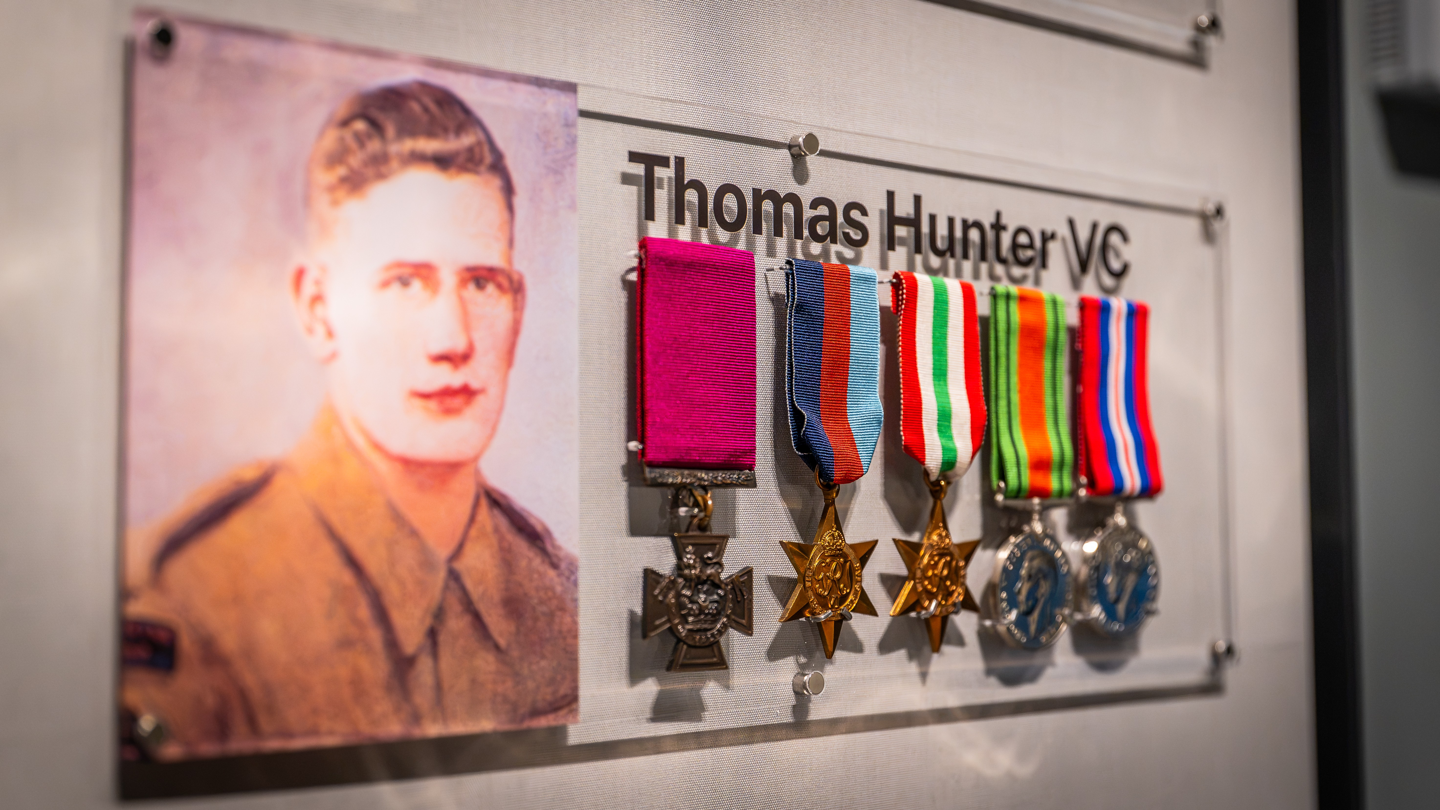 Medals of Thomas Hunter VC displayed beside an archive portrait at the Royal Marines Experience