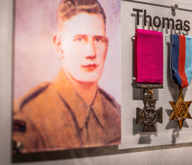 Medals of Thomas Hunter VC displayed beside an archive portrait at the Royal Marines Experience