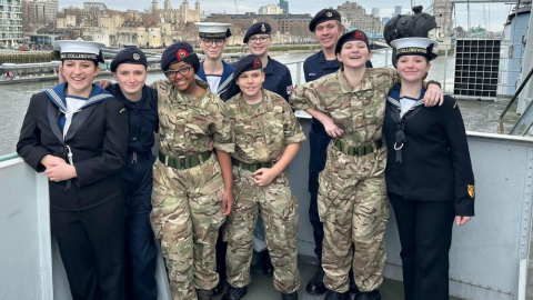 Small group of children in uniform with tower bridge behind them