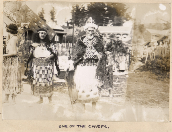 A group of Maori's in traditional clothing with the Chief in the centre. 