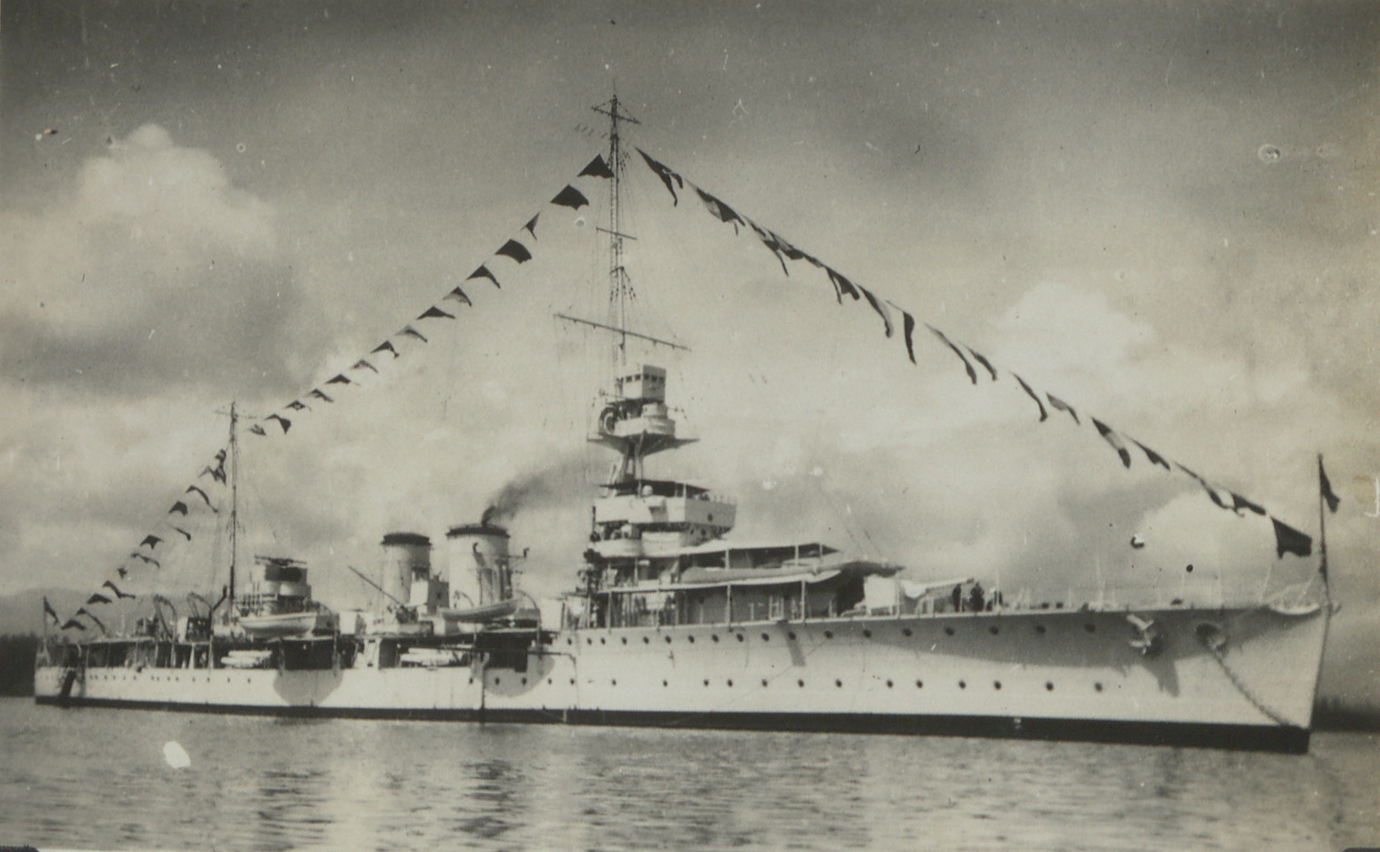 HMS Dauntless at sea with ship pennants on display. 