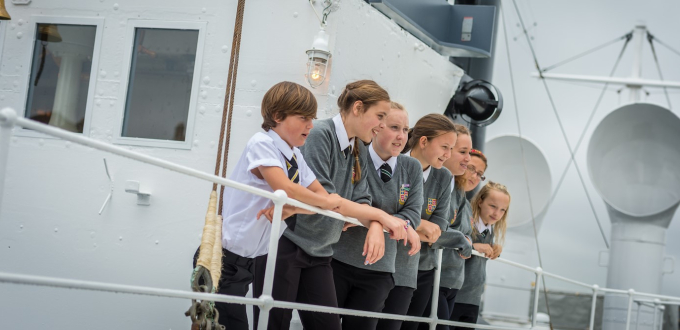 Four school children standing on the top deck of HMS M.33.