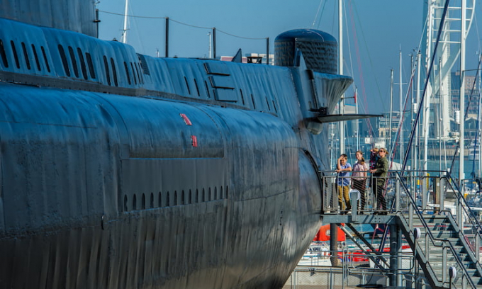 A family standing at the entrance to HMS Alliance. 