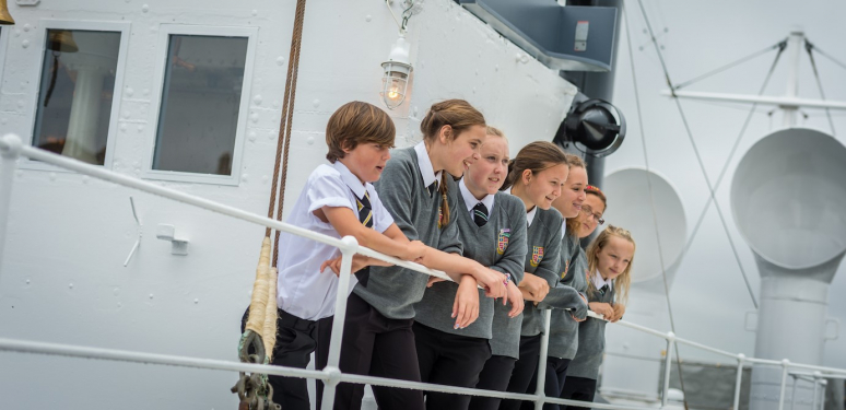 Four school children standing on the top deck of HMS M.33.