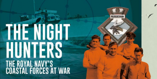 A group of Night Hunters in front of the ship badge for HMS Hornet. 
