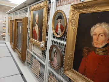A wall covered in various paintings of naval officers in our collection.