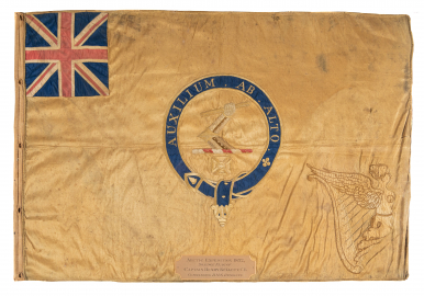 A beige flag with a Union Jack on the top left corner and a Latin inscription in the centre.  