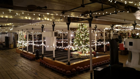 The inside of HMS Warrior decorated with Christmas lights.