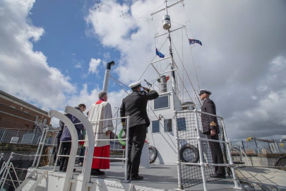 Naval Officers saluting the flag on the top deck of HMS M.33.