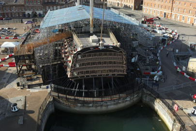 HMS Victory sits in dry dock with repair scaffolding to protect her from the weather.