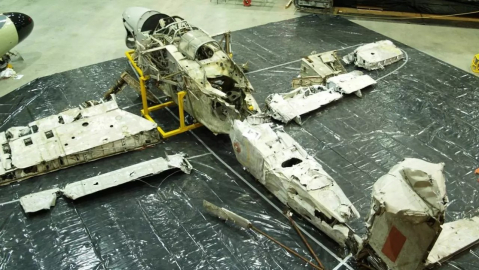 Remains of a Fairey Barracuda aircraft laid out on tarpaulin at the Fleet Air Arm Museum.
