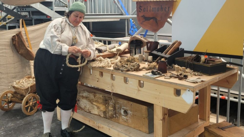 A costume interpreter shows traditional rope making skills inside Victory Live.