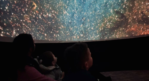 Family looking at the stars within the Wonderdome at the National Museum of the Royal Navy Hartlepool.
