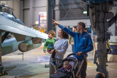 family of 4 with young children looking at the planes on display