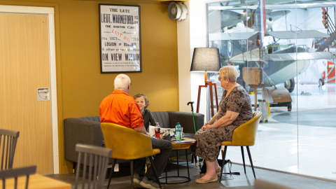 An elderly couple sit with a young boy at a table in a cafe