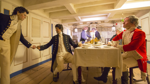 Costumed figures recreate a Georgian naval officers' dinner aboard a period warship, in a living history display at Royal Navy Museums: Hartlepool