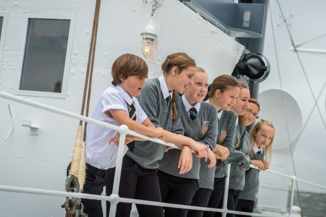 Four school children standing on the top deck of HMS M.33.