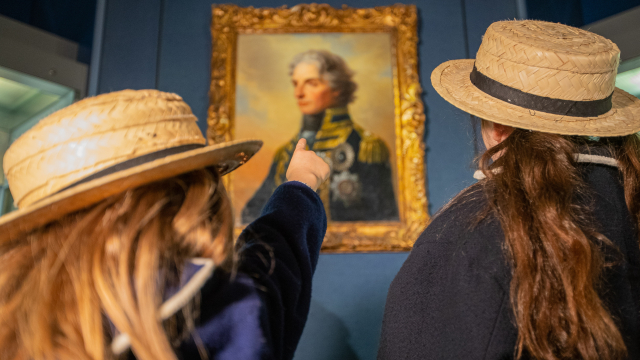 Two school girls learn about Vice Admiral Lord Nelson in the gallery dedicated to him. 