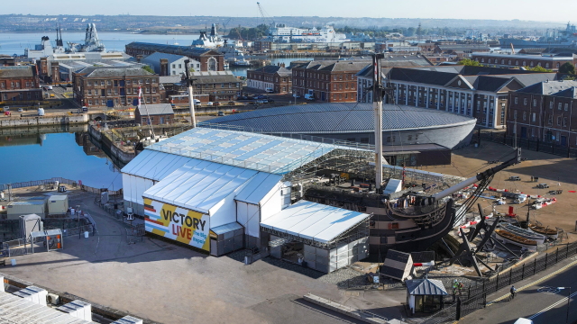 HMS Victory encased in scaffolding and plastic covers indicating that conservation work is ongoing.