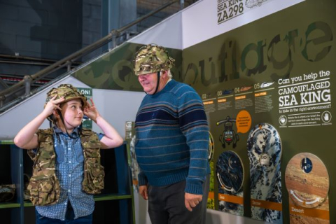 A grandfather and grandson try on replica khaki helmets and flak jackets at the Fleet Air Arm Museum.
