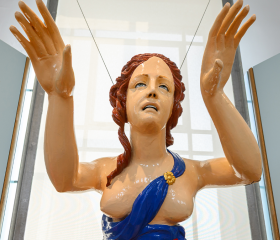 Figurehead statue of a woman with red hair and a blue dress