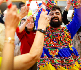 Performer in traditional dress leading a dandiya stick dance at the 'Diwali at the Dockyard' event