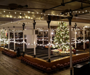 The inside of HMS Warrior decorated with Christmas lights.