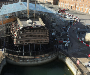 HMS Victory sits in dry dock with repair scaffolding to protect her from the weather.