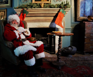 Santa Claus relaxing in a recreation of a Georgian study, complete with stockings above the fireplace. The study is part of a recreated Georgian quayside at the National Museum of the Royal Navy Hartlepool