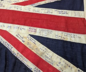 A close-up of a Union Jack flag with many names written on it.