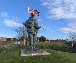 A large bronze statue of a Royal Marine with a Union Jack coming out of his backpack.
