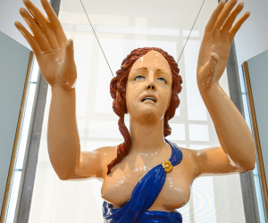 Figurehead statue of a woman with red hair and a blue dress