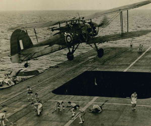 A historic image of an aircraft flying from a carrier