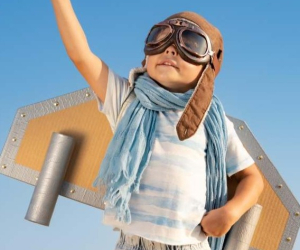 Active Aviators' promotional image of a child in pilot goggles and cardboard wings, arm raised.