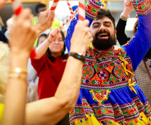 Performer in traditional dress leading a dandiya stick dance at the 'Diwali at the Dockyard' event