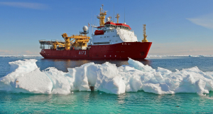 HMS Protector navigating past an ice burg whilst out at sea. 