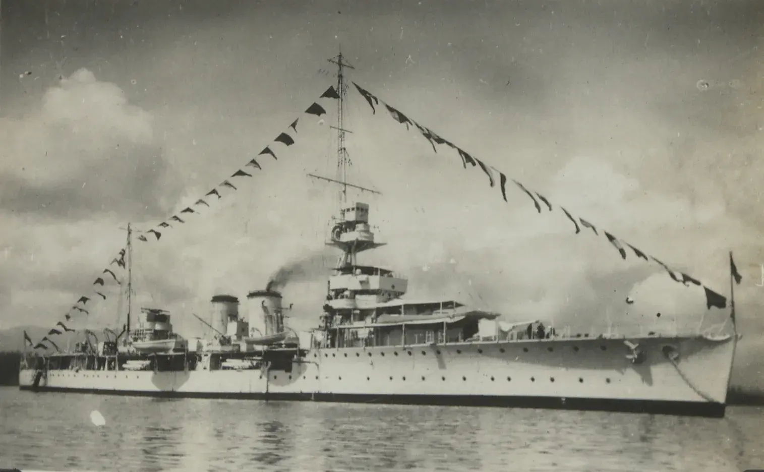 HMS Dauntless at sea with ship pennants on display. 
