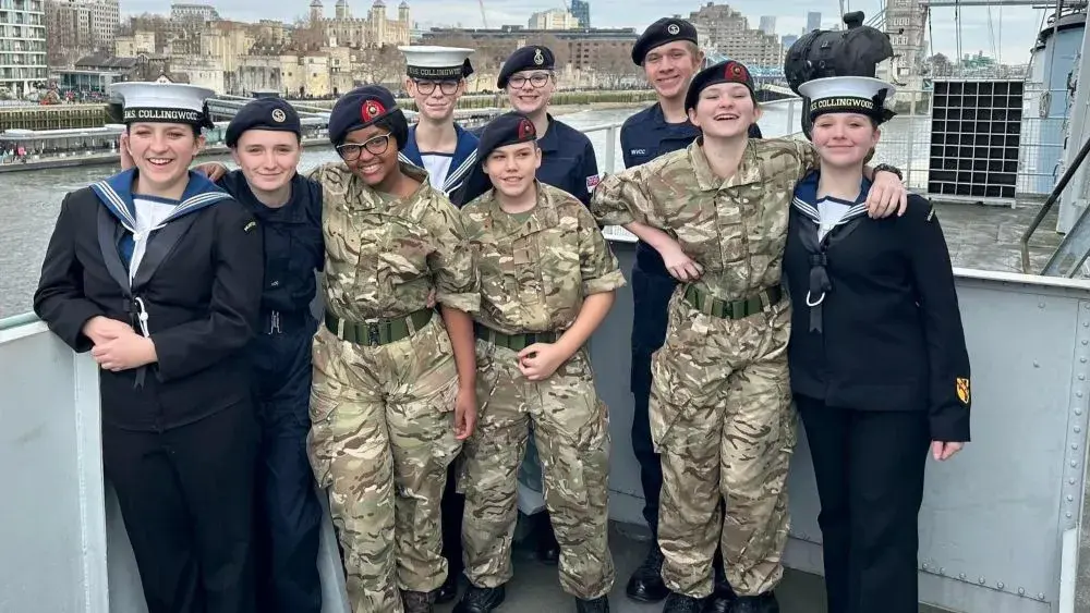 Small group of children in uniform with tower bridge behind them